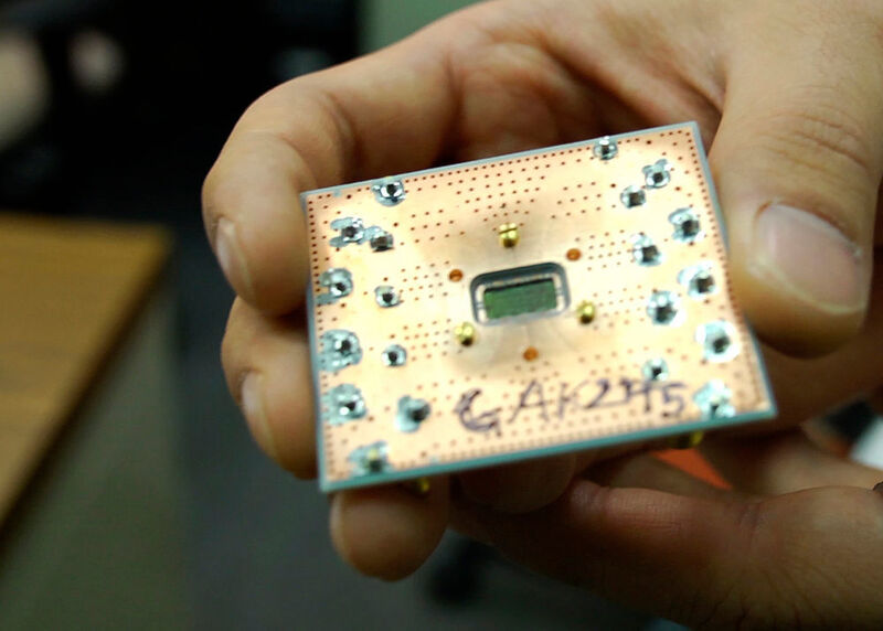 Die Abbildung zeigt einen Silizium-Chip mit insgesamt drei Qubits im Maßstab von Maßstab: 8 Millimeter x 4 Millimeter. Der Chip ist rückseitig auf einer Leiterplatte montiert und wird über Drahtbindungen mit I/O-Koaxialleitungen verbunden. Eine größere Anordnung solcher Qubits und Resonatoren soll für eine skalierbare Architektur verwendet werden. (IBM Research)