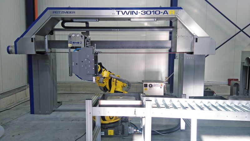 Vollautomatisierte Bandschleifmaschine mit Roboterhandling und automatischer Teilezu- und abfuhr mittels angetriebener Rollenbahnen. (Peitzmeier)