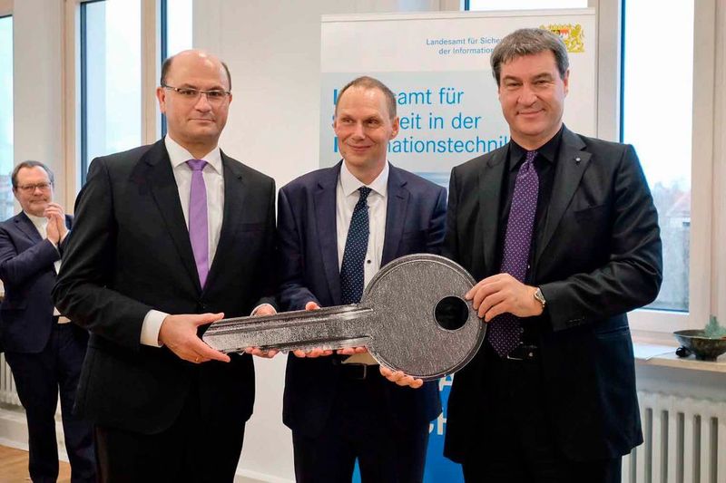 Staatsminister Dr. Markus Söder (r.), Staatssekretär Albert Füracker (l.) und Ministerialrat Daniel Kleffel, den kommissarischen Leiter des neuen Landesamts, bei der Schlüsselübergabe (© Bayerisches Finanzministerium)