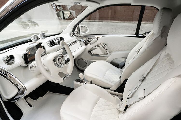 Auch im Cockpit hat Jeremy Scott einen Wechsel aus Weiß und Chrom entworfen. Die Instrumententafel, die Türen und beide Sitze sind mit weißem Nappaleder mit Rautenmuster bezogen. Die Lautsprecher tragen ebenso wie die Türgriffe Chrom. (Foto: Smart)
