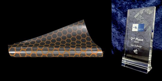 Modell der Sensorfolie zur Messung der Materialbelastung von Luft- und Raumfahrzeugen im Flug. Rechts die Trophäe, mit der diese Idee ausgezeichnet wurde.(Bild:  Alexander Hilgarth / Universität Würzburg)
