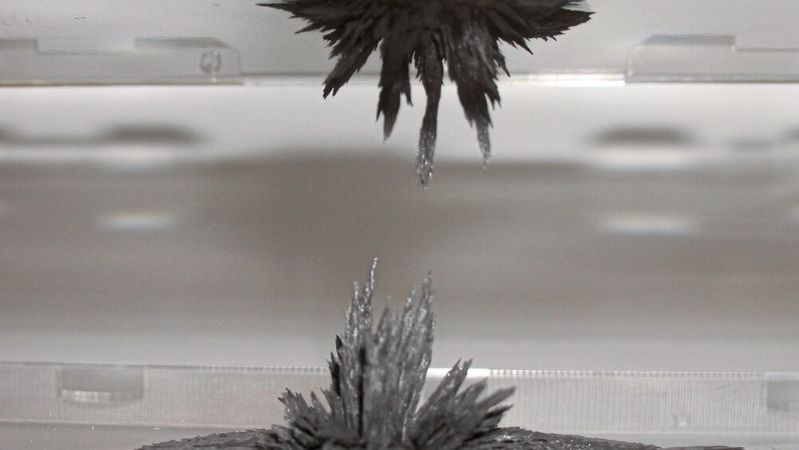 Magnetrheologische Flüssigkeiten versteifen sich beim Anlegen eines Magnetfeldes und werden zu einem festen Gel, d.h. die Veränderung entspricht einem Phasenübergang von einer flüssigen in eine quasi feste Phase.(Bild:  MRF zwischen zwei Permanentmagneten /INVENTUS Engineering GmbH / CC BY-SA 3.0)