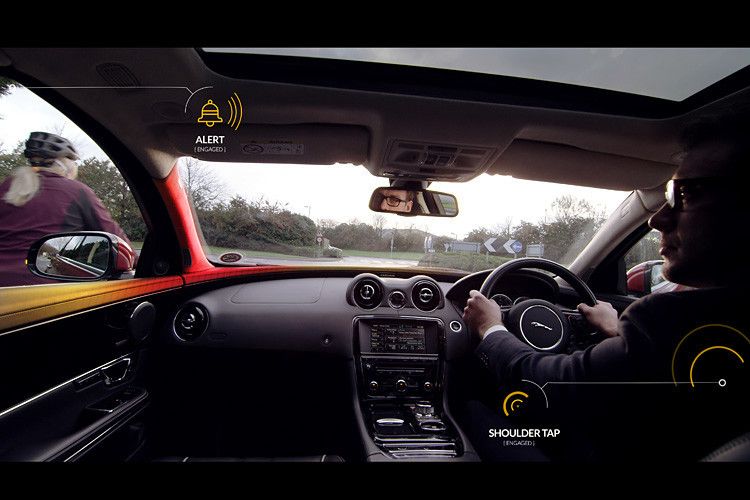 Taucht ein Fahrrad oder Motorrad hinter dem Wagen auf und setzt links oder rechts dazu an, vorbeizuziehen, gibt Bike Sense dem Fahrer einen sanften Wink und „tippt“ ihm behutsam auf die Schulter. Instinktiv wirft der Pilot einen Blick aus dem Fenster und kann den vorbeifahrenden Verkehrsteilnehmer als mögliches Risiko erkennen. (Foto: Jaguar Land Rover)