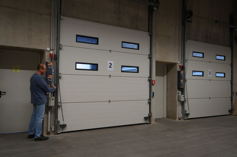 Die vorgelagerten Verladestationen des Gauselmann Logistikzentrums sind mit Industrie-Sectionaltoren SPU F42 abgeschlossen. Eine Sandwich Verglasung sorgt für den sicheren Blickkontakt zur Verladestation. (Hörmann)