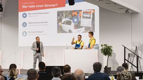 Klare Ansage von der Bühne: Holger Parsch (mit erhobenem Zeigefinger), Robin Schürer und Produzent Lars Faust von den VOX-„Autodoktoren" appellierten an die Werkstätten, sich mit der E-Mobilität zu beschäftigen. (Bild: Stefan Bausewein)