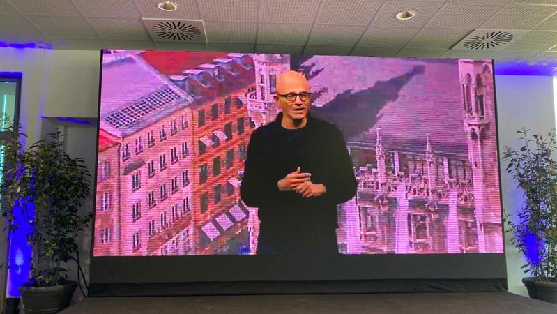 „Wir wollen jeden einzelnen leistungsfähiger machen und neue Möglichkeiten erschließen“: Microsoft-CEO Satya Nadella wurde aus den Eisbachstudios per Videoschalte in die Pressekonferenz übertragen. Im Hintergrund ein Foto des Münchner Marienplatzes.(Bild:  Rüdiger)