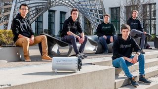 Die Projektleiter des TUM Boring Teams auf der Treppe der TU München mit dem Modell der Tunnelbohrmaschine. Von links nach rechts: Haokun Zheng, Elias Schmid, Max Herbst, Kilian Schmid, Marvin von Hagen. (Andreas Heddergott / TUM)