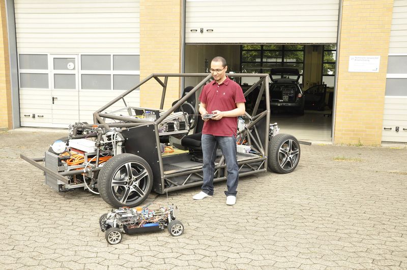 Mobile und Max: Bashar Ibrahim, Student und Stipendiat am Institut für Regelungstechnik, zeigt das Mobile-Auto im Grössenvergleich mit Max, dem Übungs-Modell im 1:5-Massstab. (Bild: TU Braunschweig)