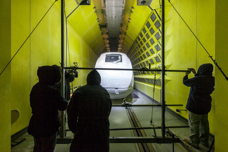 Die Ingenieure von Rail Tec Arsenals (RTA) in Wien sind dick eingepackt in ihre Winterjacken. Schal und Kapuze sind bei Minusgraden unerlässlich. Sie stehen im eisigen Wind und richten die Schneekanonen aus: dicke Schläuche, die mit hohem Druck ein Luft-Wasser-Gemisch auf den Zug sprühen, das noch in der Luft zu Schnee gefriert. So lassen sich beispielsweise Eispanzer und Schneewehen erzeugen. (Siemens)