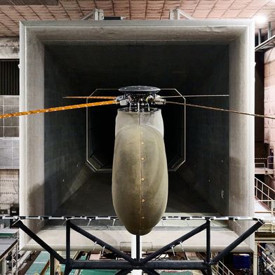 Der Rotor mit aktiv verwindbaren Rotorblättern im Windkanal:
Die offene Messstrecke und schallabsorbierende Wand- und Modellrumpf-verkleidungen ermöglichen hochwertige akustische Messungen. (Bild: DLR )