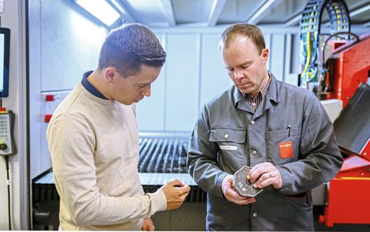 Dr. Elia Iseli (li., Gruppenleiter, Empa) prüft gemeinsam mit Roland Bader (Senior Process Engineer, Bystronic) die Schnittkanten eines gelaserten Bauteils.(Bild:  Roland Richter / Empa)