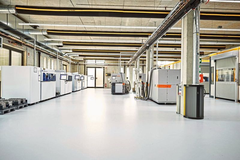 Rechts in der Produktionshalle integriert sind Kabinen, die beispielsweise Reinigungsmaschinen für das Entpulvern der Bauteile nach dem Baujob enthalten. (Toolcraft)