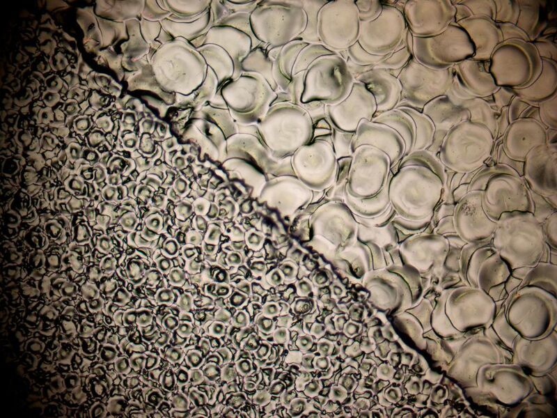 Mikroskopische Aufnahme einer mit und ohne 3DS erodierten Oberfläche. Beide Flächen haben denselben Ra-Wert 0,8µ. In der unruhigeren Topograhie der linken Fläche ohne 3DS verhakt sich der Kunststoff und läßt sich so deutlich schwerer entformen als in der oberen, deutlich homogeneren Fläche, die mit der 3DS-Technologie hergestellt wurde. (GF Machining Solutions)