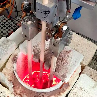 Was man beim ersten Blick für Vanillepudding mit Himbeersoße halten könnte, erfreut den Gaumen nicht wirklich. Denn hier blickt man auf eine Schmelzwanne, in der Braunglas hergestellt wird. Das Besondere: Das geht jetzt ohne Probleme auch mit Strom, statt, wie bisher, mit Gas ... (Bild: TU Bergakademie Freiberg)