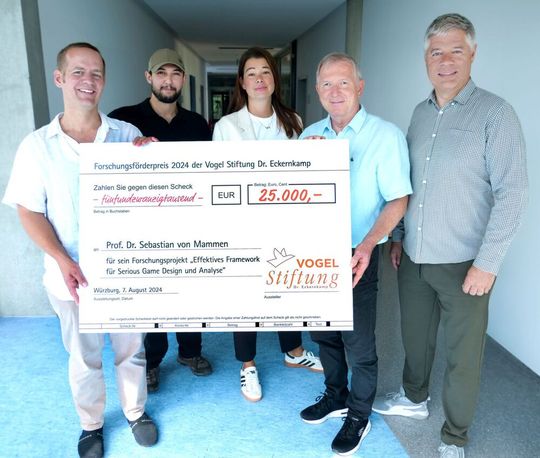 Serious Games erhält den Vogel-Stiftungs-Forschungsförderpreis. Von links: Prof. Dr. Sebastian von Mammen und Mousif Chetitah vom Lehrstuhl Mensch-Computer-Interaktion der JMU. Daneben Erhard Frank, Catharina Kipping und Gunther Schunk von der Vogel Stiftung Dr. Eckernkamp.(Bild:  S. Hofmann / JMU)