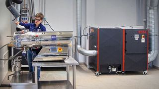 Der Entstauber Dustomat Dry von Esta erfasst via Absaugarm punktgenau die Stäube, die beim Befüllen des BHS-Horizontaltrockners entstehen. (Bild: Esta)