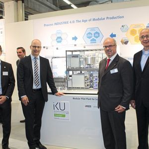 Von links nach rechts: Dr. Christoph-Fleischer-Trebes (Invite), Dr. Thomas Brackemeyer, Dr. Wolfgang Podesta und Dr. Joachim Waldi (alle Lanxess) vor dem Modell der Reel-Pilotanlage