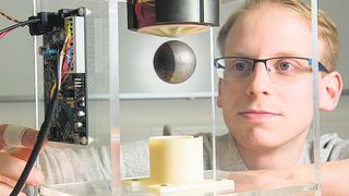 Niklas König aus der Arbeitsgruppe von Prof. Nienhaus verdeutlicht mit der schwebenden Kugel das große Potenzial des neuen Ansteuerverfahrens.  (Universität des Saarlandes (Oliver Dietze))