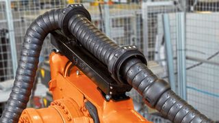 Igus hat mit Triflex RSEL ein Rückzugsystem für seine Energieketten entwickelt. Dieses sorgt dafür, dass die E-Kette möglichst kompakt am Roboterarm gehalten wird. Das System verhindert, dass die herabhängende Energieführung die Bewegungen des Roboters beeinflusst oder blockiert, auch bei hochdynamischen Anwendungen.  (Igus )
