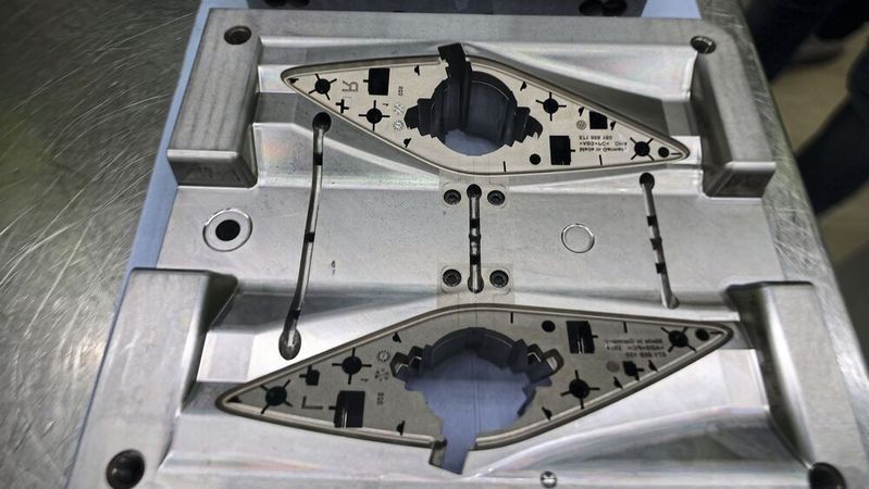 The back of the speaker grill — the sprue system of the four-cavity mould for left and right parts is clearly visible. The ejector set is mounted directly in the center. (Source:  Pergler Media)