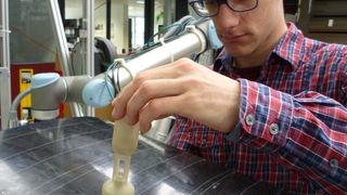 Julian Kunze demonstriert den Prototypen seines Vakuum-Greifers. (Uni Saarland/Filomena Simone)