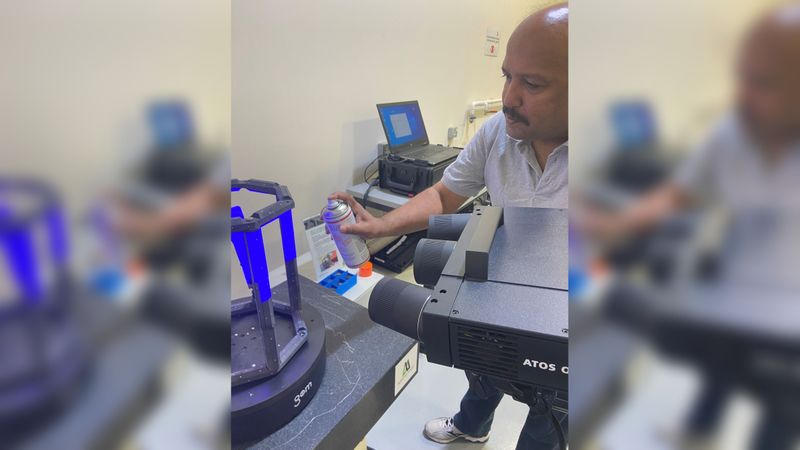 Das gedruckte Teil ist im modularen Rahmen fixiert. Die Bauteiloberfläche wird mit dem Scanning-Spray AESUB orange mattiert. (Bild:  AFS)