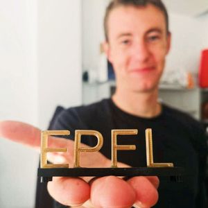 Lorenz Manker, le chercheur principal de l'étude, tenant un logo de l'EPFL imprimé en 3D avec le bioplastique.(Source :  Stefania Bertella)