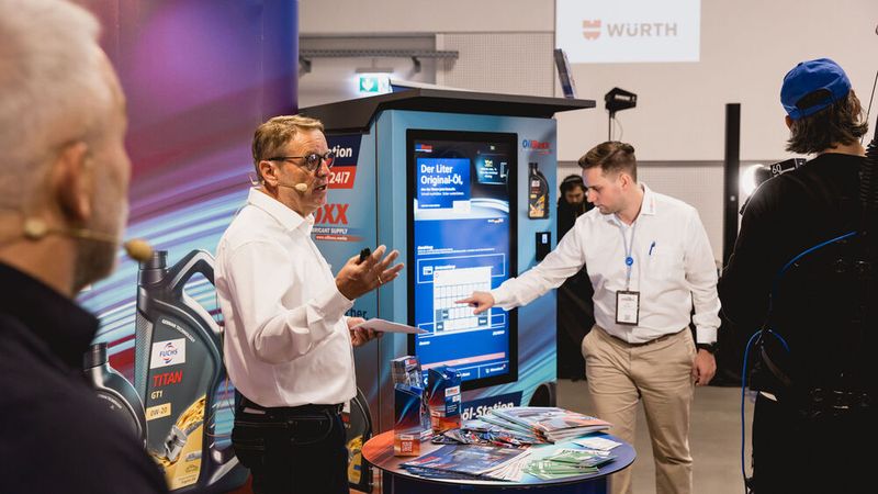 Parallel dazu lief in allen Pausen die Live-Werkstatt, ein Format mit kurzen, praxinahen Vorträgen und Demonstrationen. Wie z.B. hier: Michael Radig (Fuchs) und Thomas Hermann (Boxx Solutions) zeigten die OilBoxx, einen Verkaufsautomat für Motoröl.  (Bild: Stefan Bausewein)