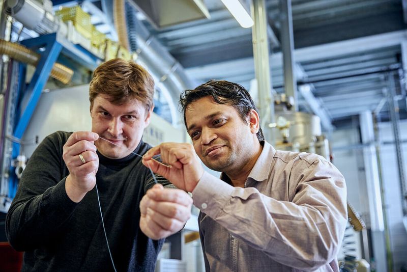 Wissenschaftler Pavan Manvi von der RWTH Aachen University (rechts) und Forscher Dr. Jochen Norwig von Covestro mit dem Prototyp einer Kunststofffaser aus CO2. (Covestro)