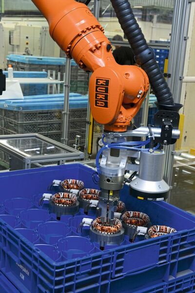Mit einem Mehrfachgreifer entnimmt der Kuka-Roboter die Statoren aus den Kleinladungsträgern.  (Kuka)