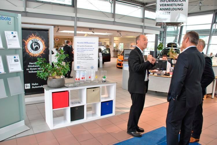 Jörg-Michael Weber, Regionalleiter Service, erklärt den Jury-Mitgliedern das „Vasen“-Konzept: Kunden können mithilfe farbiger Chips beim Verlassen des Betriebs ihre Zufriedenheit dokumentieren. (Dominsky / »kfz-betrieb«)