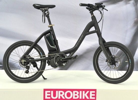Neuheiten Eurobike 2014: Flogo von FLYER Biketec AG Schweiz (Awardgewinner) Das Flogo ist auf die Anforderungen des urbanen Lifestyles getrimmt: Kompaktes Maß, elegantes Design und spritziges Fahrverhalten. Tiefer, ergonomischer Durchstieg, Größen anpassbar, robuste E-Bike Gabel, leichtes Beschleunigen durch 20 Zoll LaufrÃ¤der mit Nabenschaltung, 250 oder 350 Watt Mittelmotor von Panasonic. Die lÃ¤ssige Lenkertasche Velo-Pocket stammt aus dem neuen Sortiment der Firma Ortlieb. Model Kathrin trägt lässige urbane Freizeit-Bike-Bekleidung der Firma Triple2 (Awardgewinner).  (EUROBIKE Friedrichshafen)