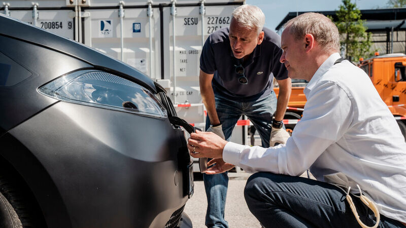 Chefentwickler Markus Vollmer öffnet die Ladeklappe am Sion – dahinter liegen auch Ausgänge, mit denen sich andere Elektroautos laden lassen. (Bild: Sono Motors)