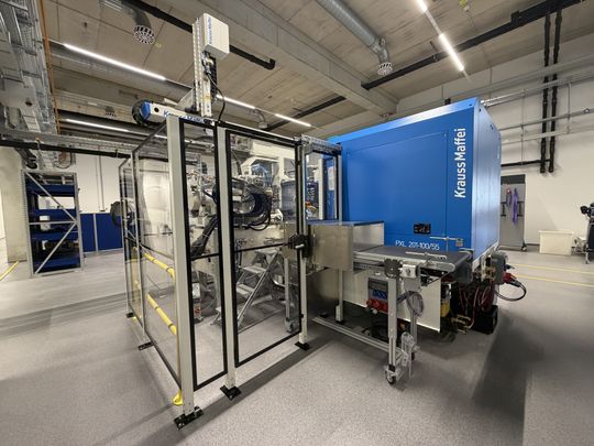 Kompakte Produktionszelle mit Entnahmehandling und Förderband der PXL 201-100/55 am Standort Waldkraiburg.(Bild:  Krauss Maffei)