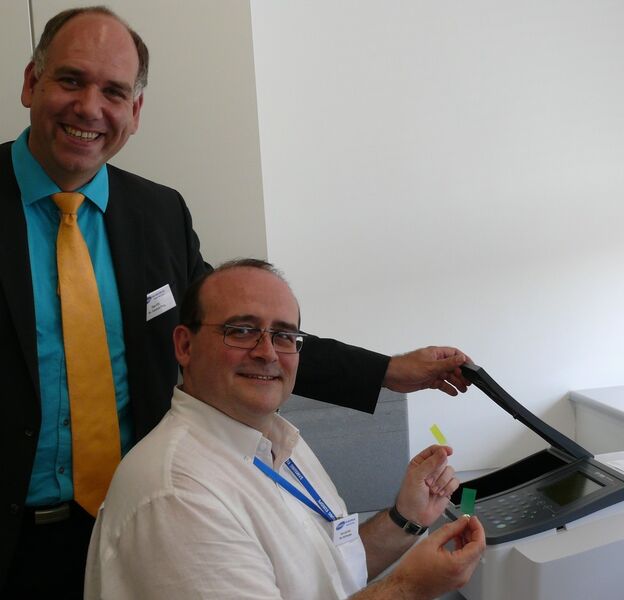 Betriebsleiter Dr. Carsten Plüg (links) und Ralf Braden messen mit dem Spektrometer die optischen Eigenschaften von Acrylatfilmen. Im Labor sollen bessere Formulierungen für das Acrylat gefunden werden – für noch brillantere Farben auf den Bildschirmen von Fernsehern, Computern und Smartphones. (Bild: Infraserv)