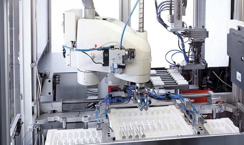 Automation: Nach der Entnahme werden die Fertigteile auf einer Kühlstation zwischengelagert, bevor sie ein Scara-Roboter nach dem First-in-first-out-Prinzip abholt und in Trays absetzt. (Bild: Arburg)