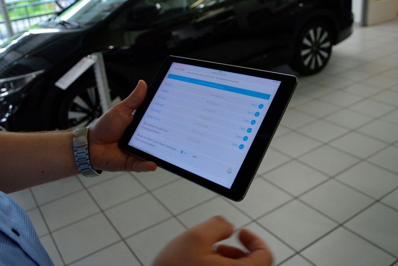 Bei der Fahrzeugauslieferung holen die Verkäufer die Kundenbewertung ein. (Achter)