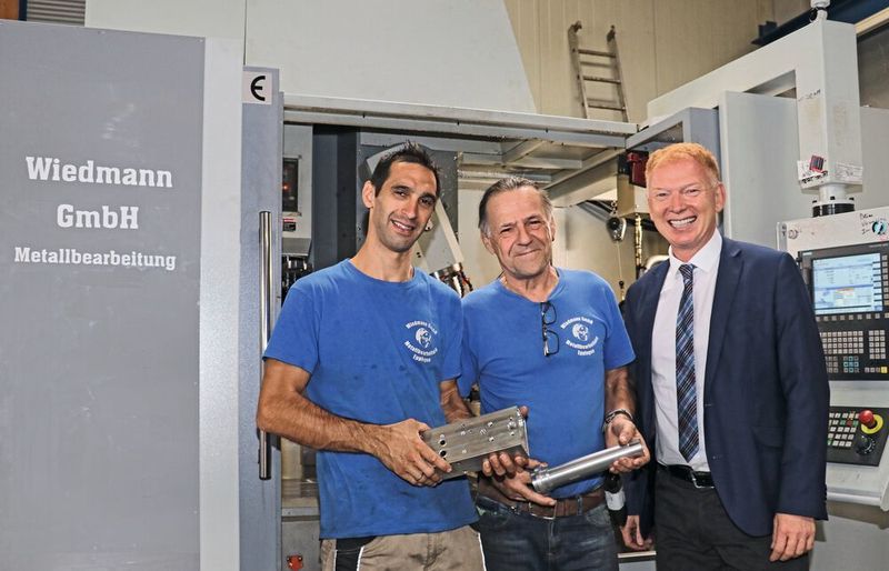 Partnerschaft seit mehr als 25 Jahren: Bruno Wiedman (Mitte) und Fabio Sousa (links) schätzen die Kontinuität und Verlässlichkeit von Wagner Maschinen. Sie freuen sich mit Raimond Wagner über die neuen 5-Achs-Zentren WMC 1100, mit denen sich komplizierte Bauteile präzise und effizient herstellen lassen. (Wagner)