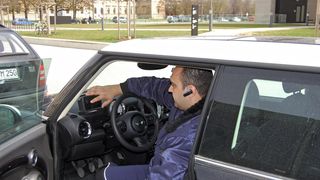 Vor der Uni: Athanasios Arabatjis überprüft die Informationen des Mini und startet dann die Reinigung des Fahrzeugs. (Bild: Weber)