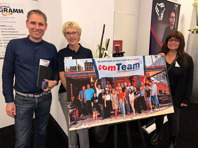 Danke an das Wortmann-Team für das Gemälde! Matthias Assmann und Silvia Habeck (comTeam) mit Beiratsmitglied Verena Müller Thiel (r., C&P) begutachten das Geschenk. (Bild: Vogel IT-Medien GmbH)