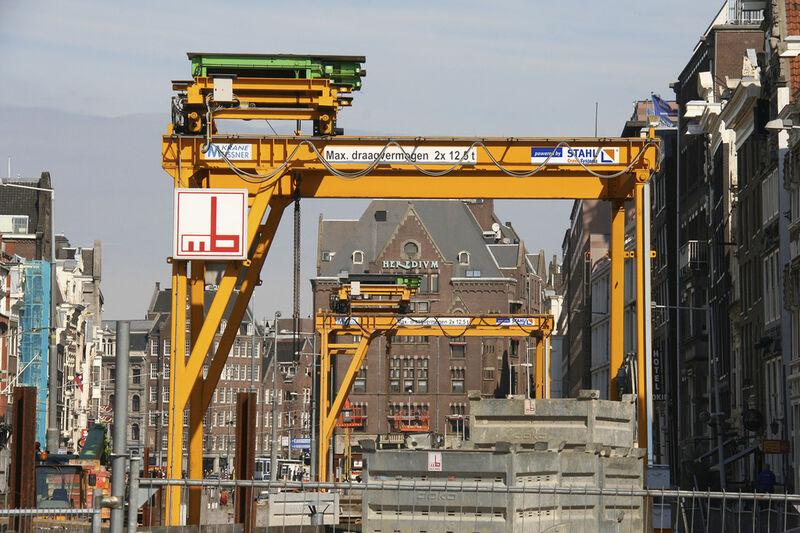 Beim Bau der neuen Nord-Süd Metrolinie in Amsterdam kommen sechs Portalkrane mit jeweils zwei AS7-Seilzügen zum Einsatz. Sie befördern Container mit Abraum aus und Werkzeuge in die Stollen der neuen U-Bahn-Linie. (Bild: Stahl Cranesystems)