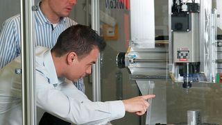 Messe-Highlight: Das Team um Jan Mertes (vorne) und Peter Simon von der TU Kaiserslautern hat für diese Fräsmaschine einen digitalen Zwilling entwickelt. Dabei werden auch Maschinendaten sowie Steuerungsbefehle per 5G-Technik übermittelt, was viele Vorteile bringt. (TUK / Koziel)