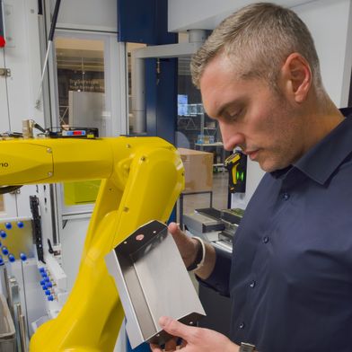 „In der Zelle“: Marc Unger, Operations Manager bei Blechnext, überprüft das mithilfe des Roboterarms in der Biegezelle automatisiert abgekantete Blechteil.   (Bild: Blechnext)