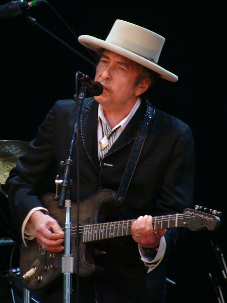 Bob Dyland's history as a rock musician began in 1965 when he replaced his acoustic guitar with an electric guitar. His records were sold millions of copies.  (Source: Bob Dylan - Azkena Rock Festival 2010 2 / CC BY-SA 2.0)