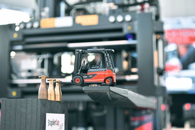 Staplercup Sponsor Westfahlen Gas richtete am Donnerstag einen kleinen Sonderwettbewerb für die Firmenteams aus – hier war Präzision gefragt: Aufgabe der Fahrerinnen und Fahrer war, mit einem auf dem Gabelzinken befestigten Staplermodell kleine Kegel in eine Box zu befördern. Nichts für schwache Nerven. (© Klaus Voit / KION Group)