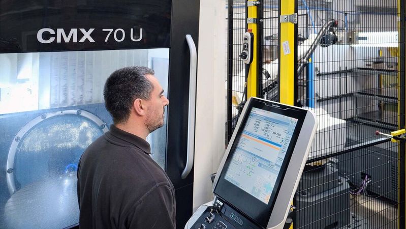 Mr Slimm at the control of the automated DMG Mori CMX 70 U VMC. The robot enclosure with safety fence and light curtain may be seen in the background.(Source:  Whitehouse Machine Tools)
