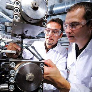 Markierte Probekörper werden für einen Zugversuch in eine Prüfmaschine eingespannt. Die genaue Kenntnis der Materialdaten ist bei der rechnerischen Auslegung von Hybridbauteilen aus Organoblech und angespritzten Funktionselementen unverzichtbar.