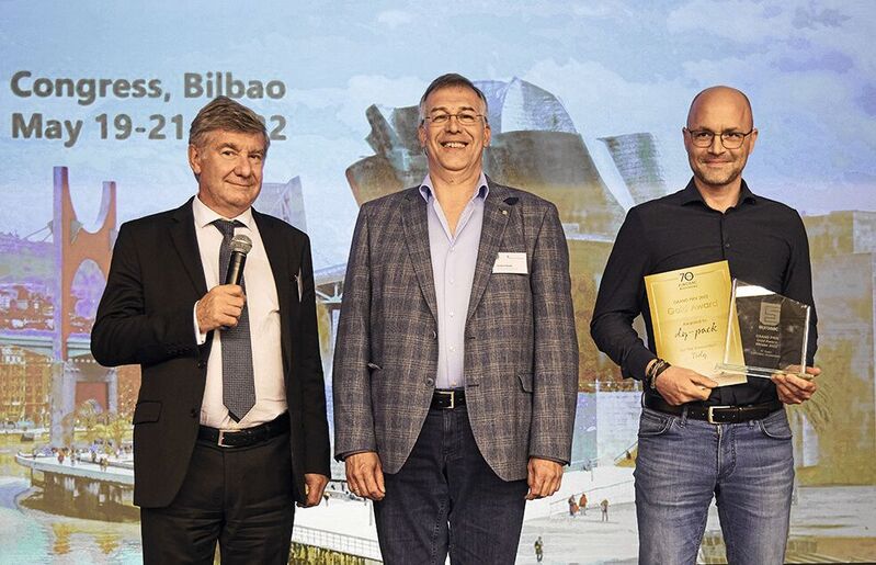 Von links nach rechts: Eurosac-Präsident Olivier Tassel und Jurypräsident Herbert Rode gratulieren dem Gewinner des goldenen Eurosac Grand Prix Award dy-pack, vertreten durch Peter Perrone. 
