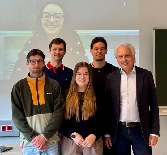 Einem Forscher-Team an der Universität Klagenfurt ist es nun gelungen, einen wesentlichen Beitrag für die Realisierung des „heiligen Grals des Problemlösens“ zu finden – der Mensch formuliert ein Problem, der Computer löst es: Francesco Zuccato, Benedetta Strizzolo (auf der Leinwand), Konstantin Schekotihin, Veronika Semmelrock, Patrick Rodler und Gerhard Friedrich (v.l.n.r.) !(Bild:  KK)
