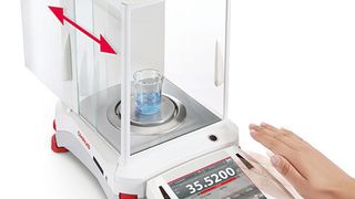 Durch eine Handbewegung öffnet sich die Windschutztür automatisch. (Bild: Ohaus)